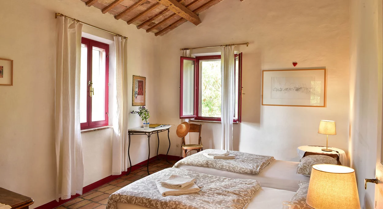 Helles Schlafzimmer mit Holzbalkendecke und zwei Betten