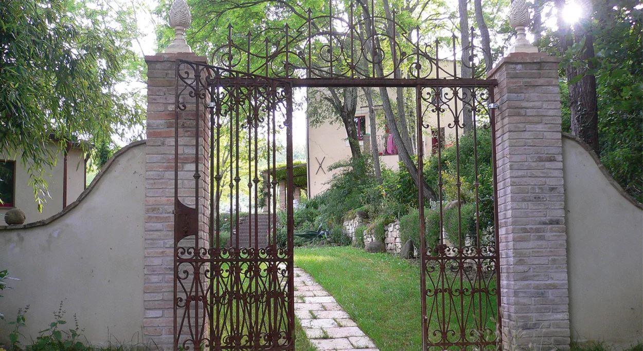 Schmiedeeisernes Tor mit Blick in den Garten der Villa Castelplanio