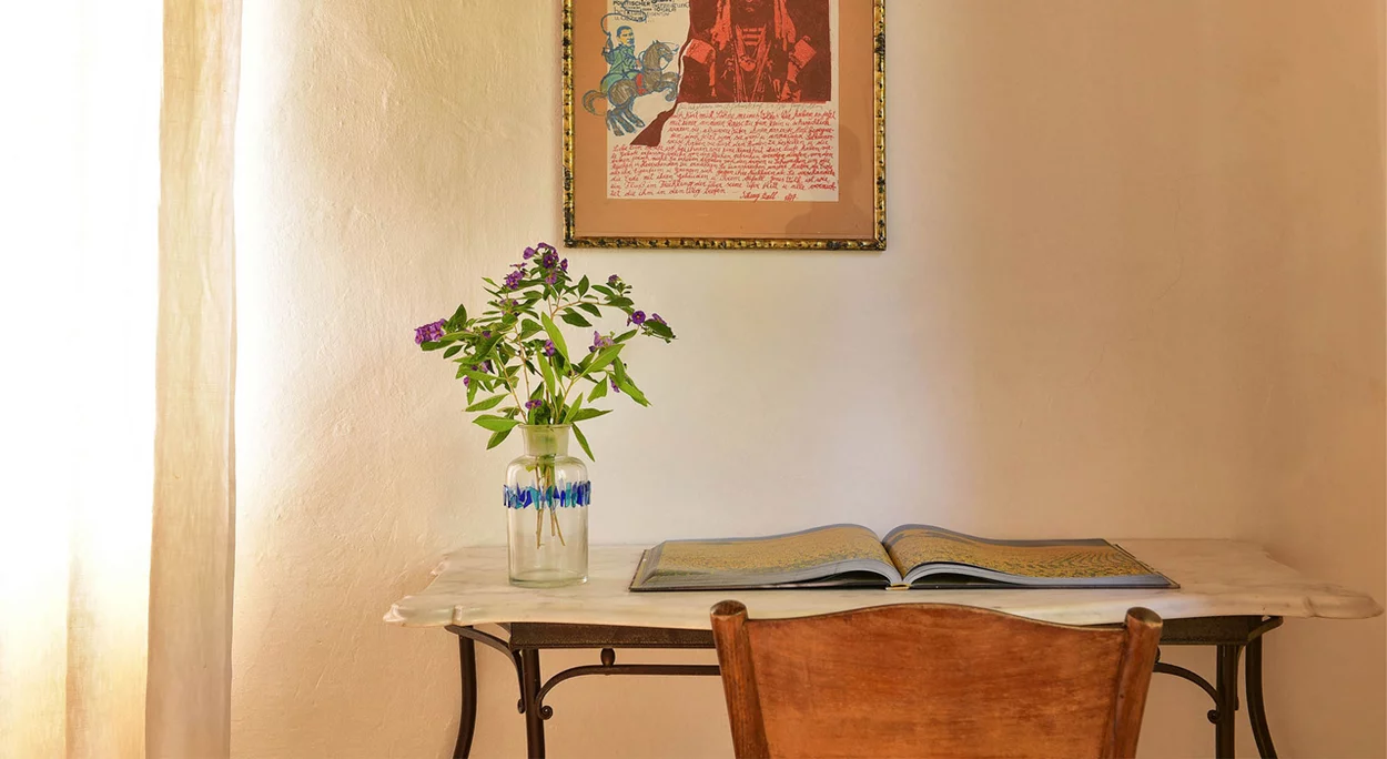 Schreibtisch mit Blumen und Bild im Zimmer